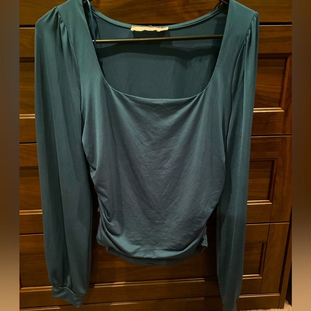 New green silk like material long sleeve top. Cinched sides make slimming cut.